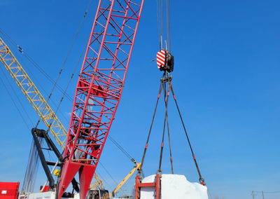Large crane hoisting shrink wrapped machinery